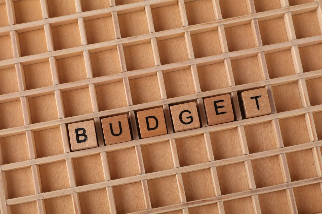 portfolio-02 Wooden letter tiles spelling 'budget' on a wooden grid background, symbolizing finance and planning.