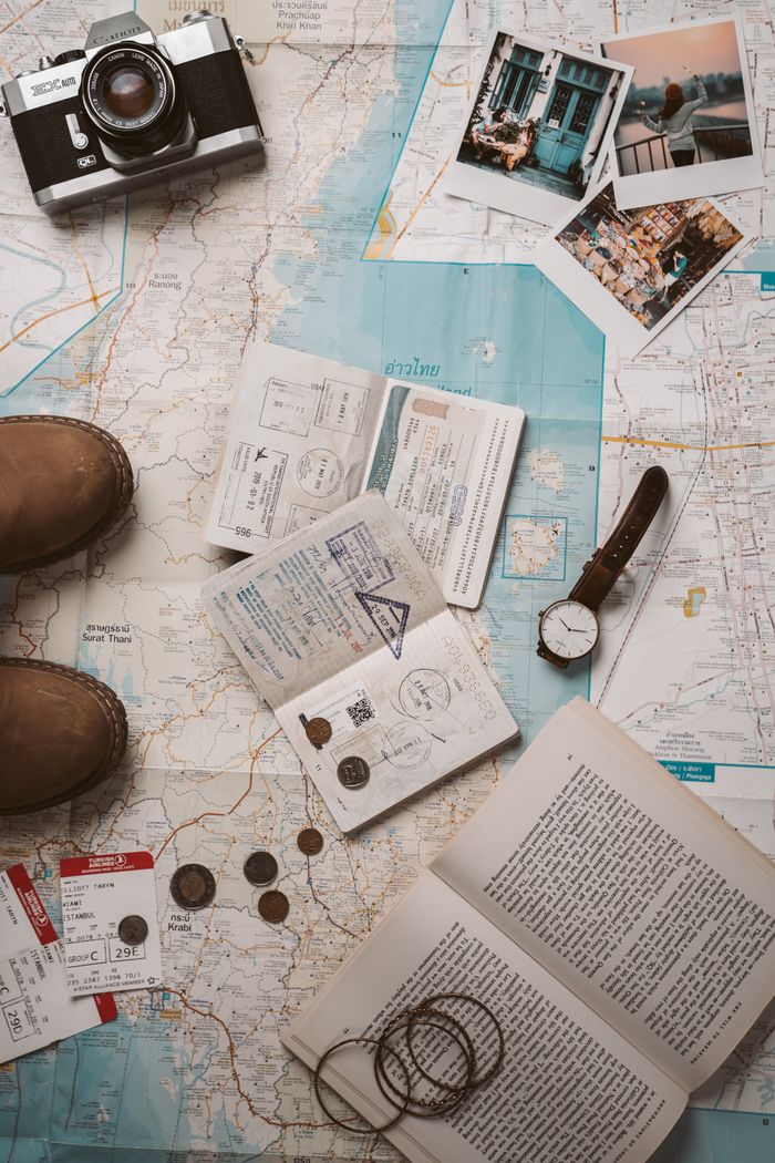 gallery-03 Flat lay of travel essentials featuring a map, camera, and passport stamps, perfect for wanderlust inspiration.